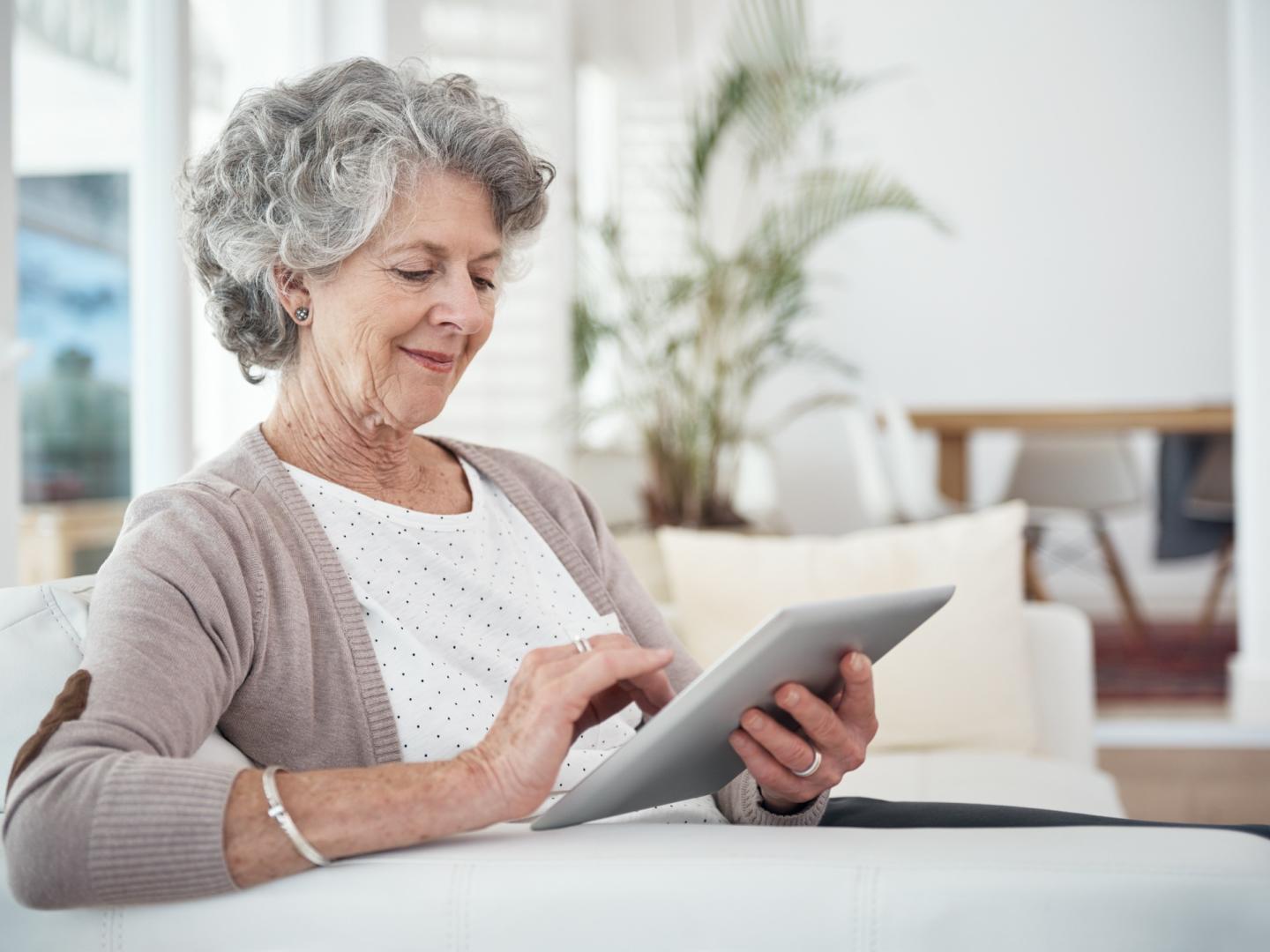 Personne âgée regardant ses courriels à partir d’une tablette