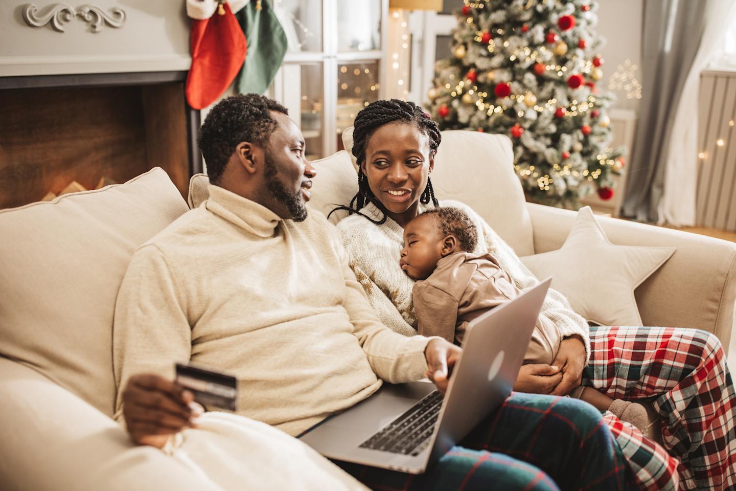 Family on couch looking at laptop 

