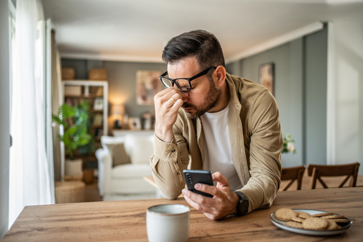 Un adulte fatigué qui regarde son téléphone intelligent 

