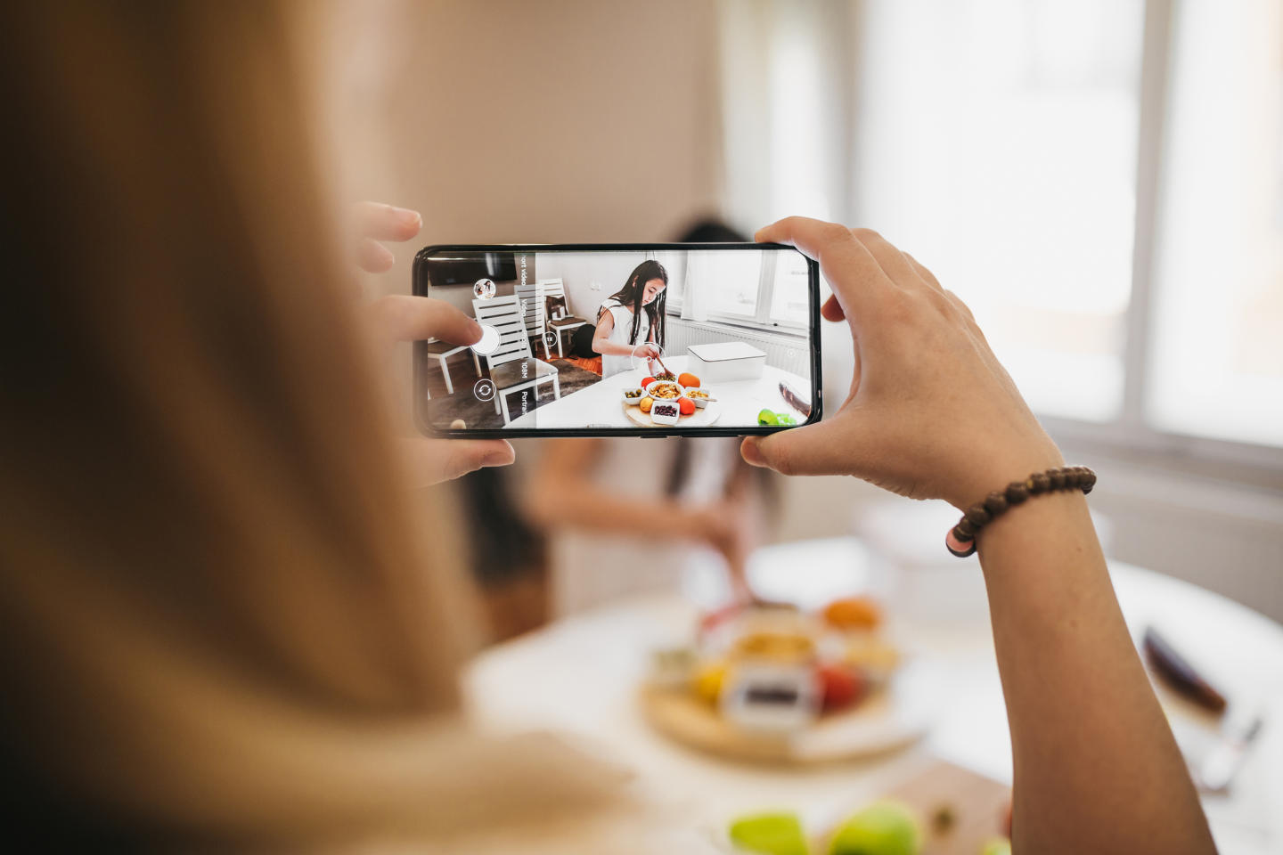 Mother filming daughter on smartphone