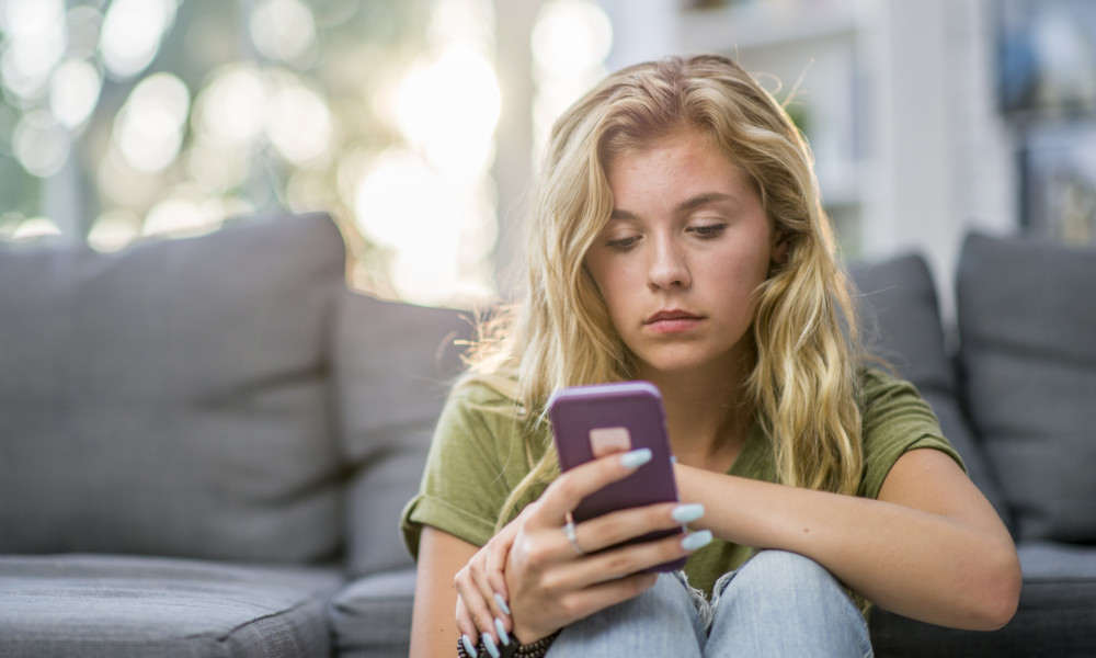 sad girl looking at phone