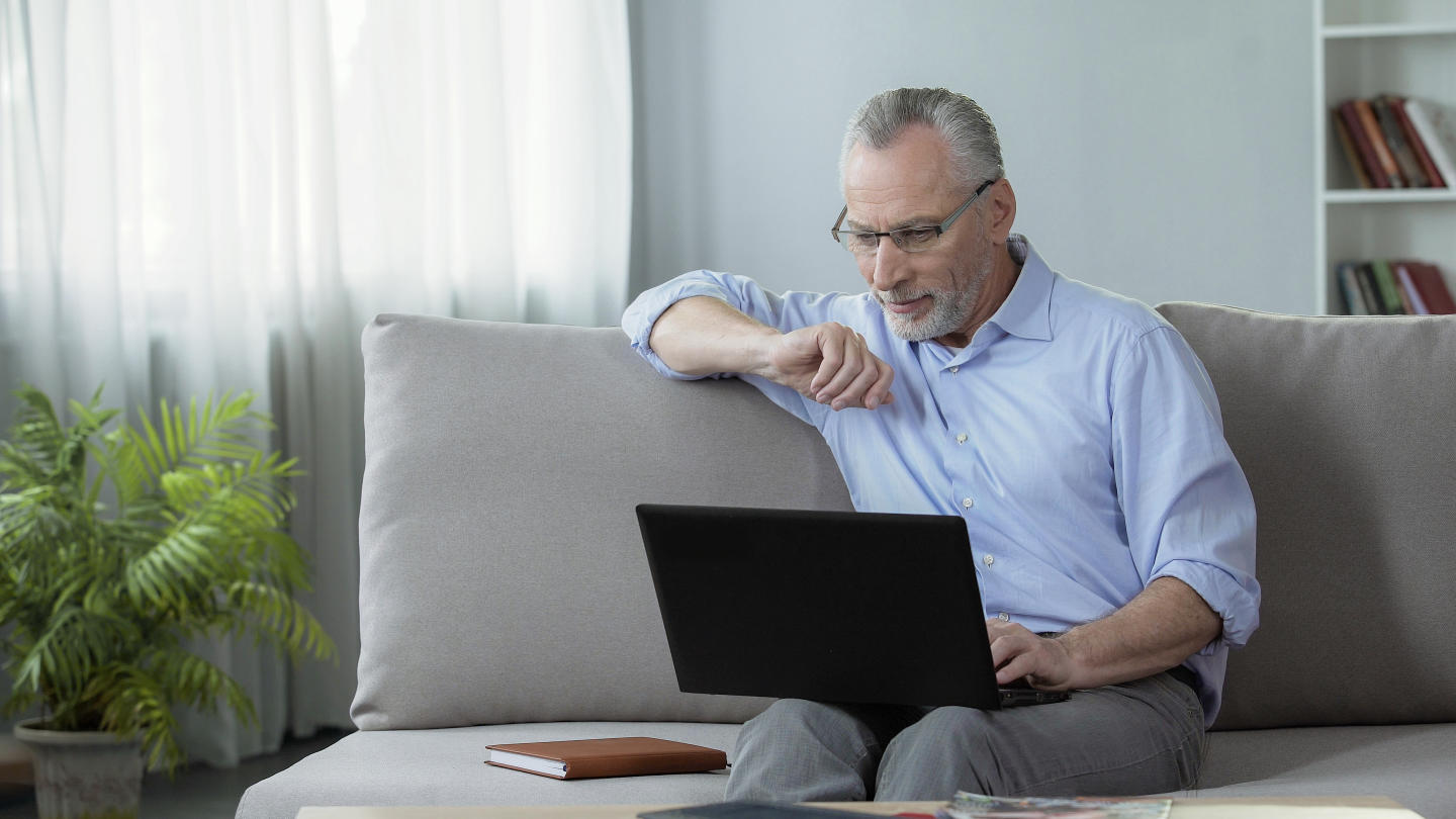 Man with laptop on couch