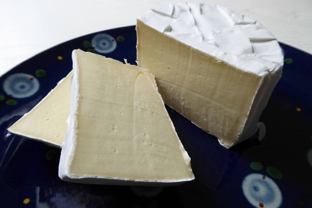 a picture of cheese on a wooden board.