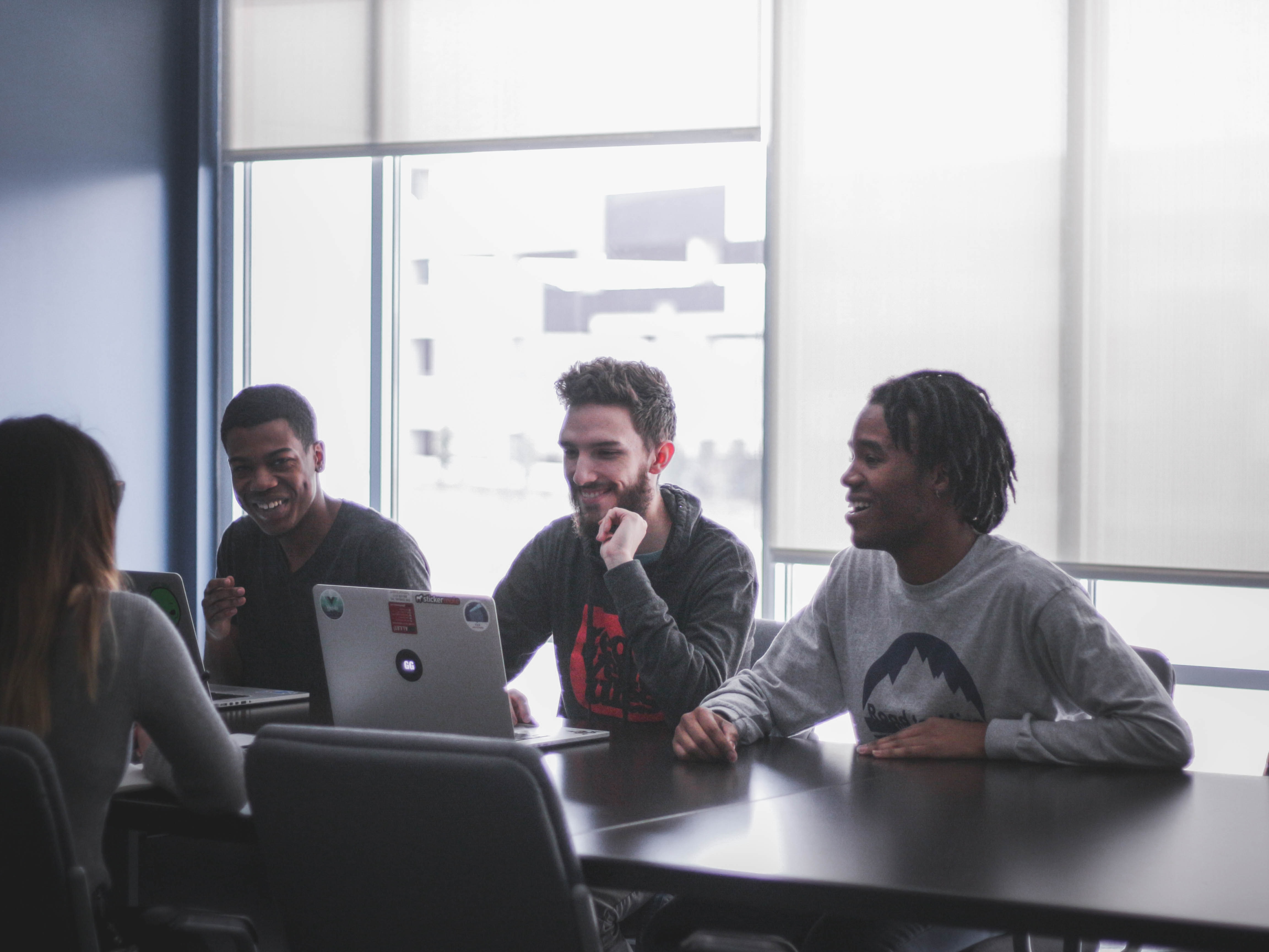 a group of young people working on a laptop.