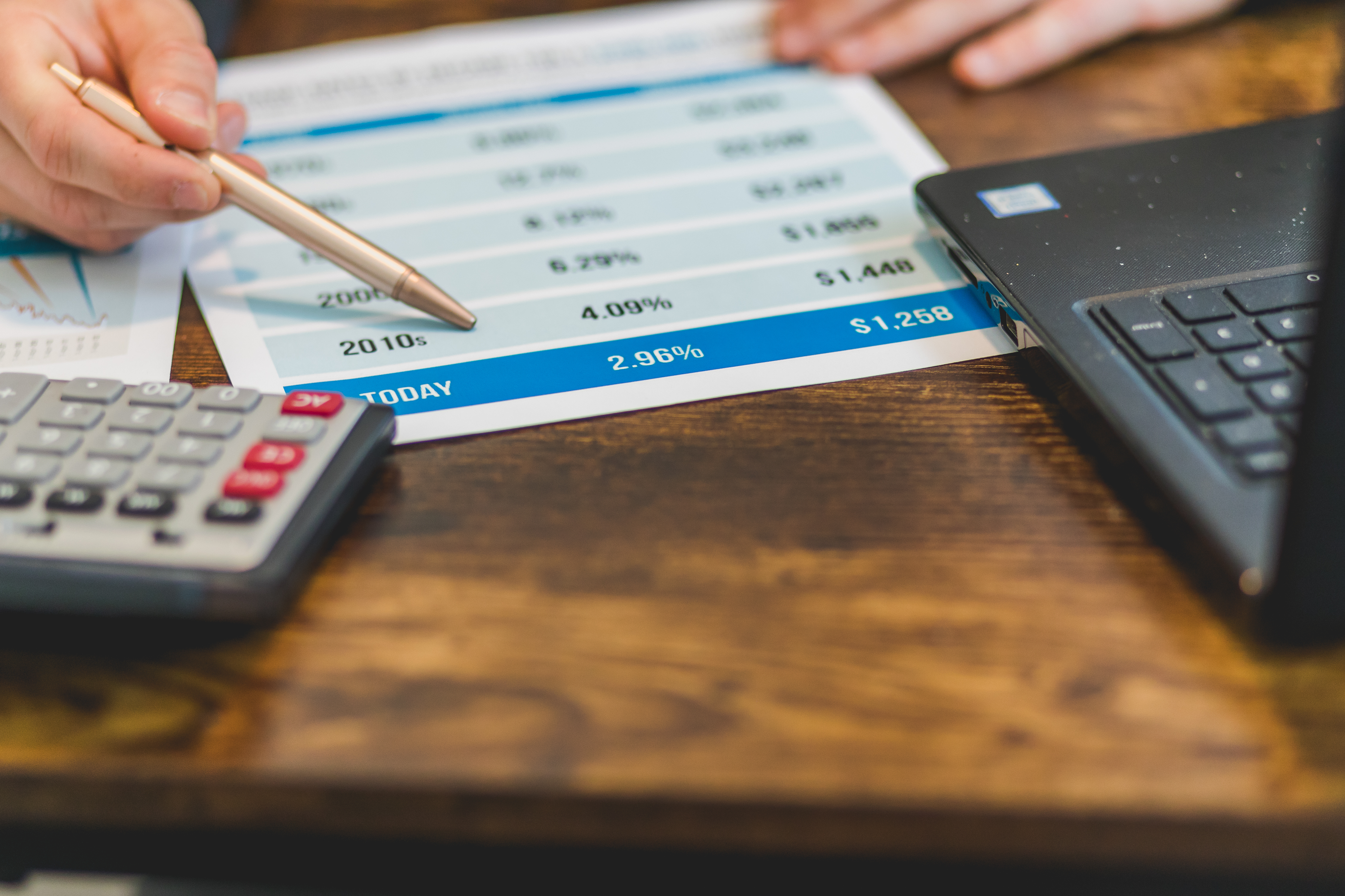 a man's hand holding a calculator and a pen.