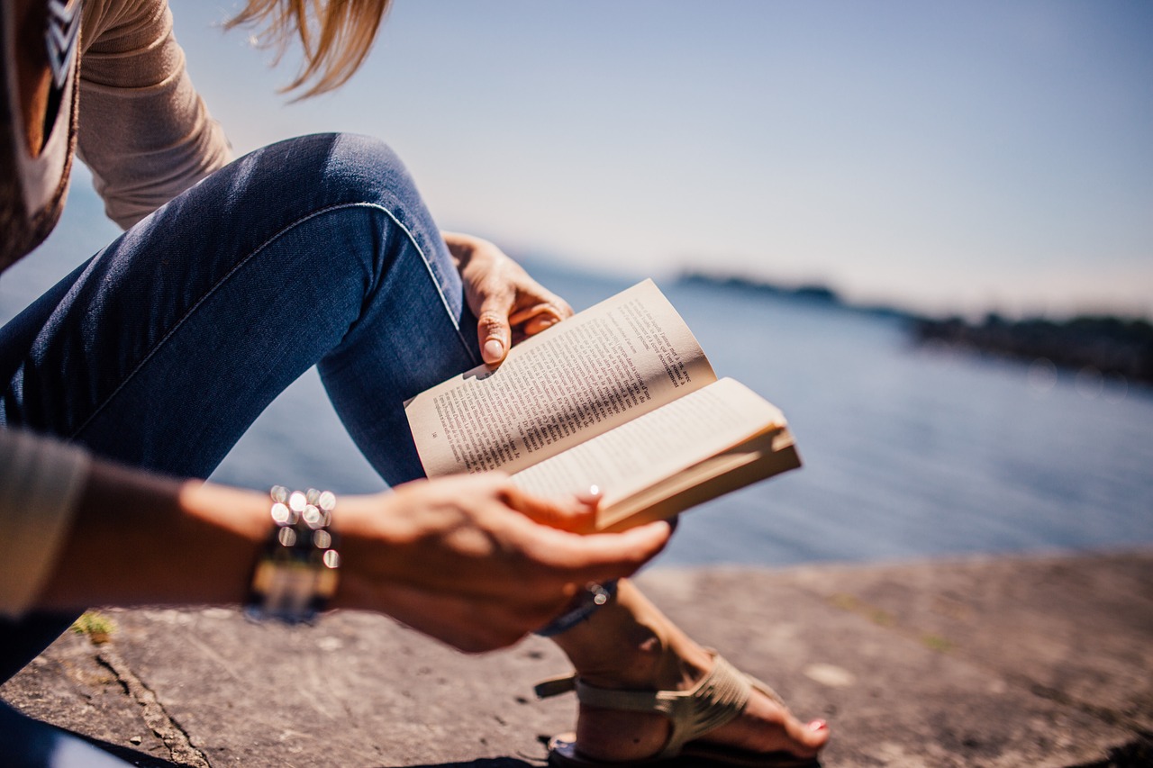 woman reading a book on the beach.