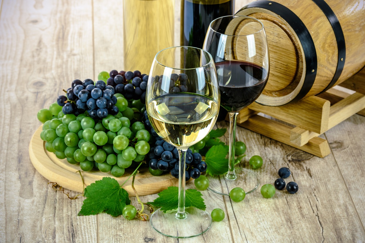 glass of white wine and grapes on a wooden table.