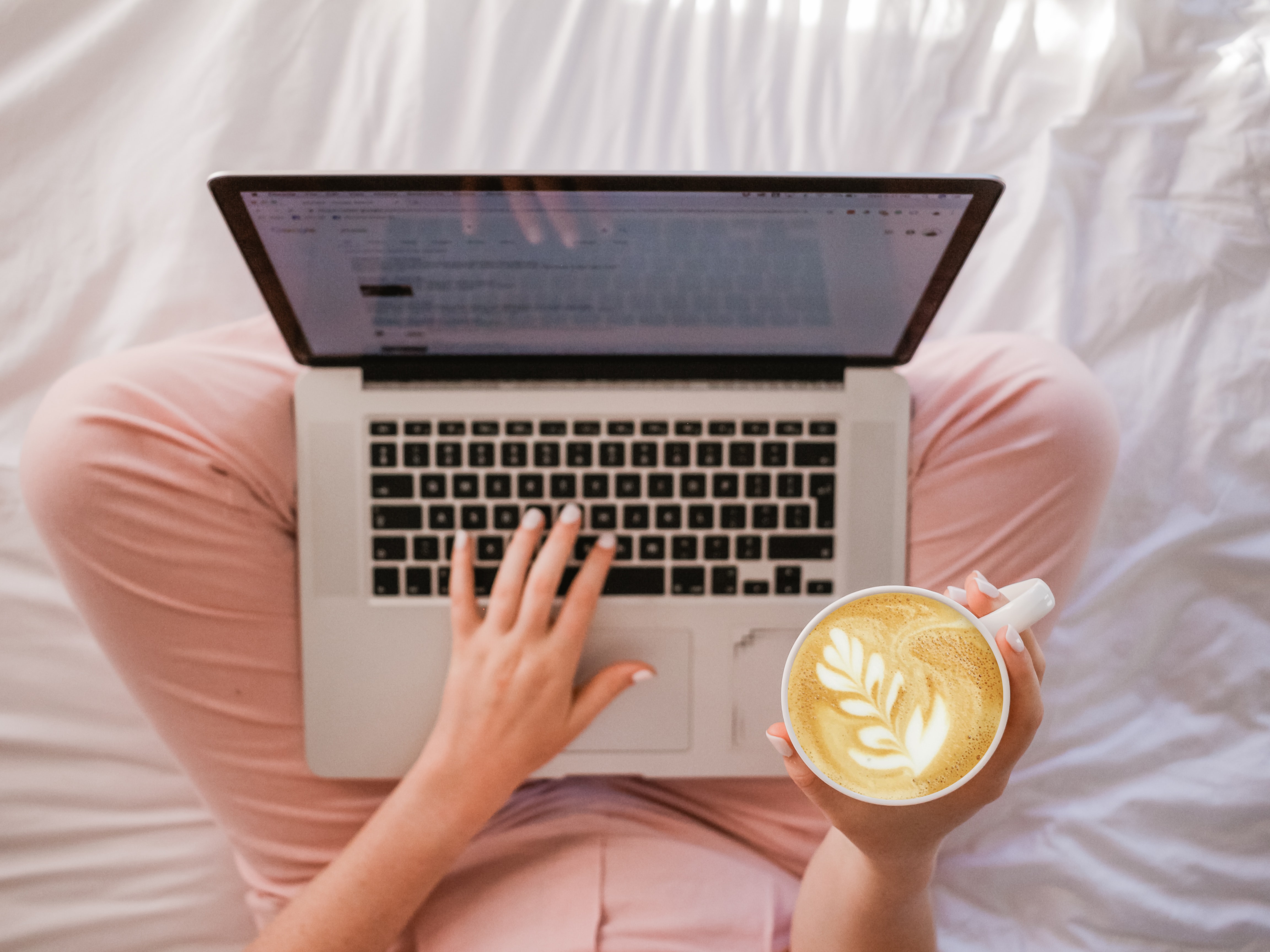 woman using a laptop and drinking coffee.