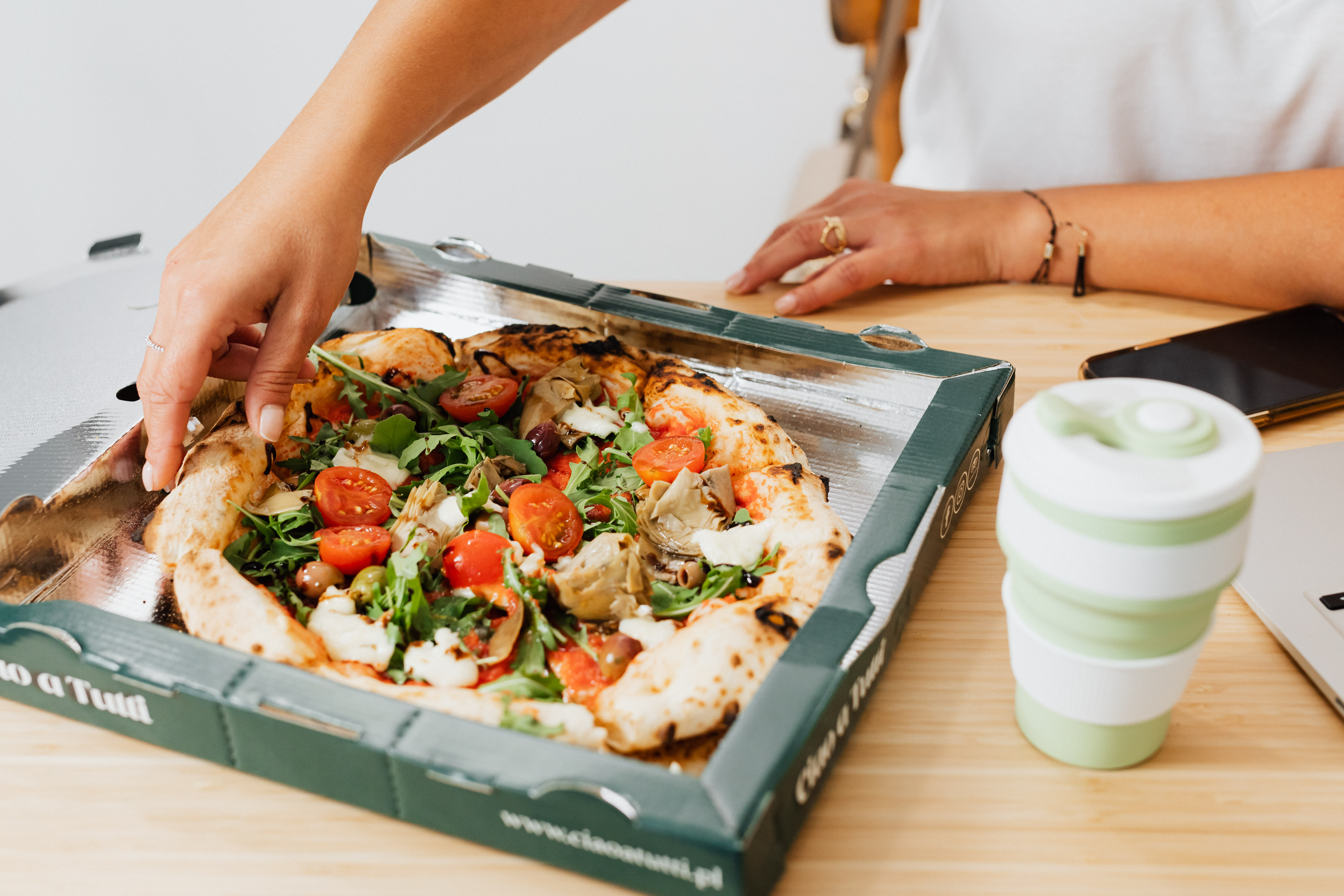 a woman holding a box of food.