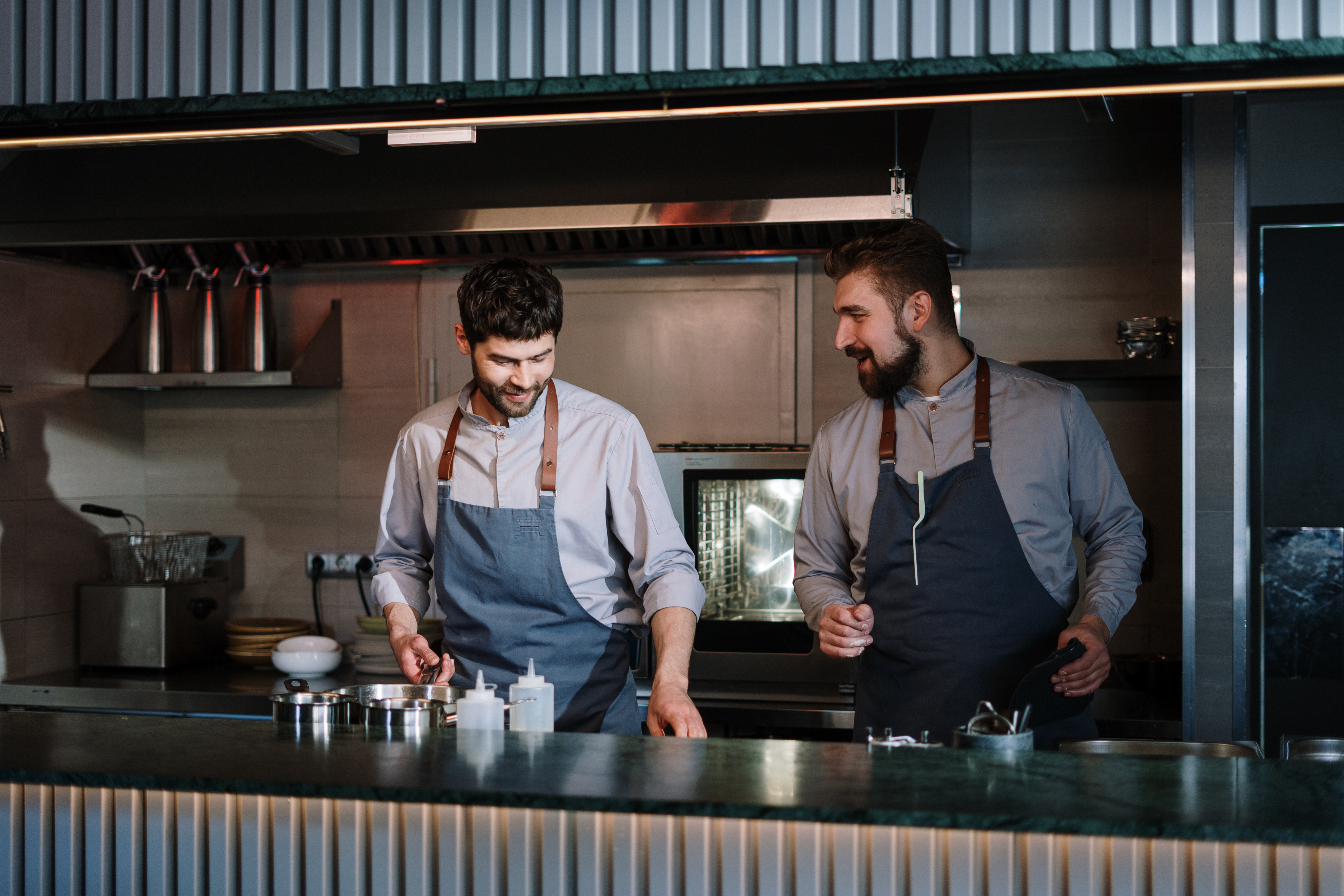 person and his team preparing food in the kitchen.