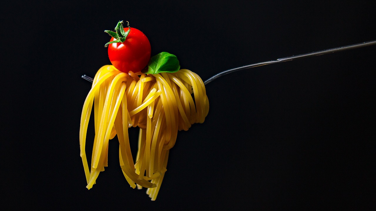 a bunch of fresh spaghetti on black background.