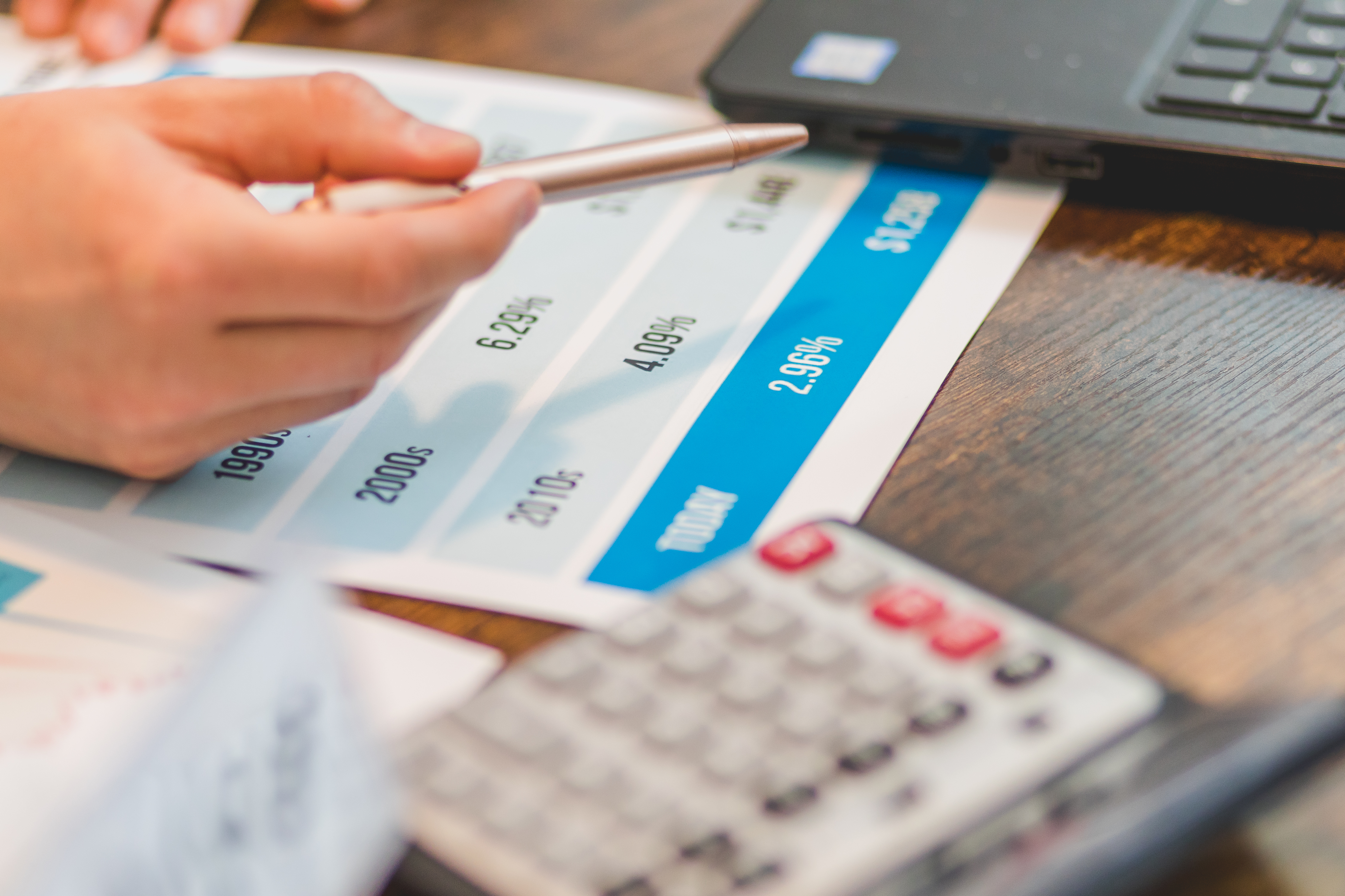 a man's hand holding a calculator and a pen.