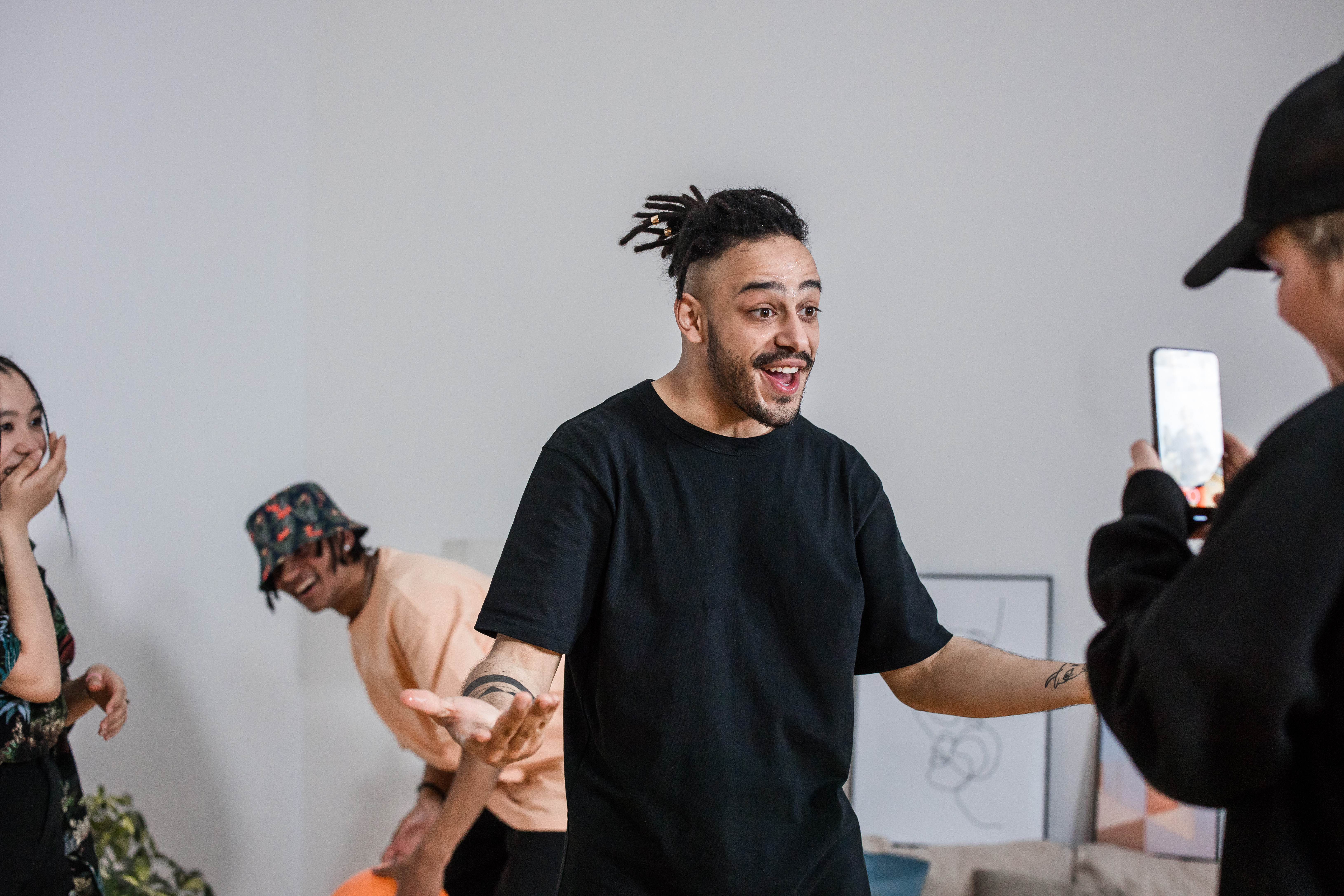 person, a young man in a black t - shirt, smiling.