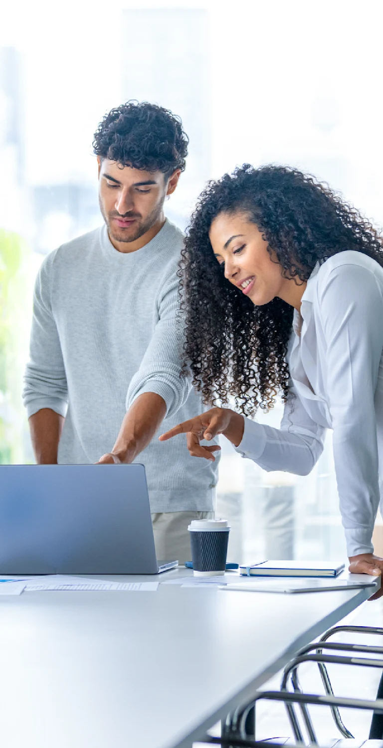 Três profissionais discutindo uma estratégia de negócios em uma reunião, com foco em trabalho em equipe, inovação e sucesso empresarial.