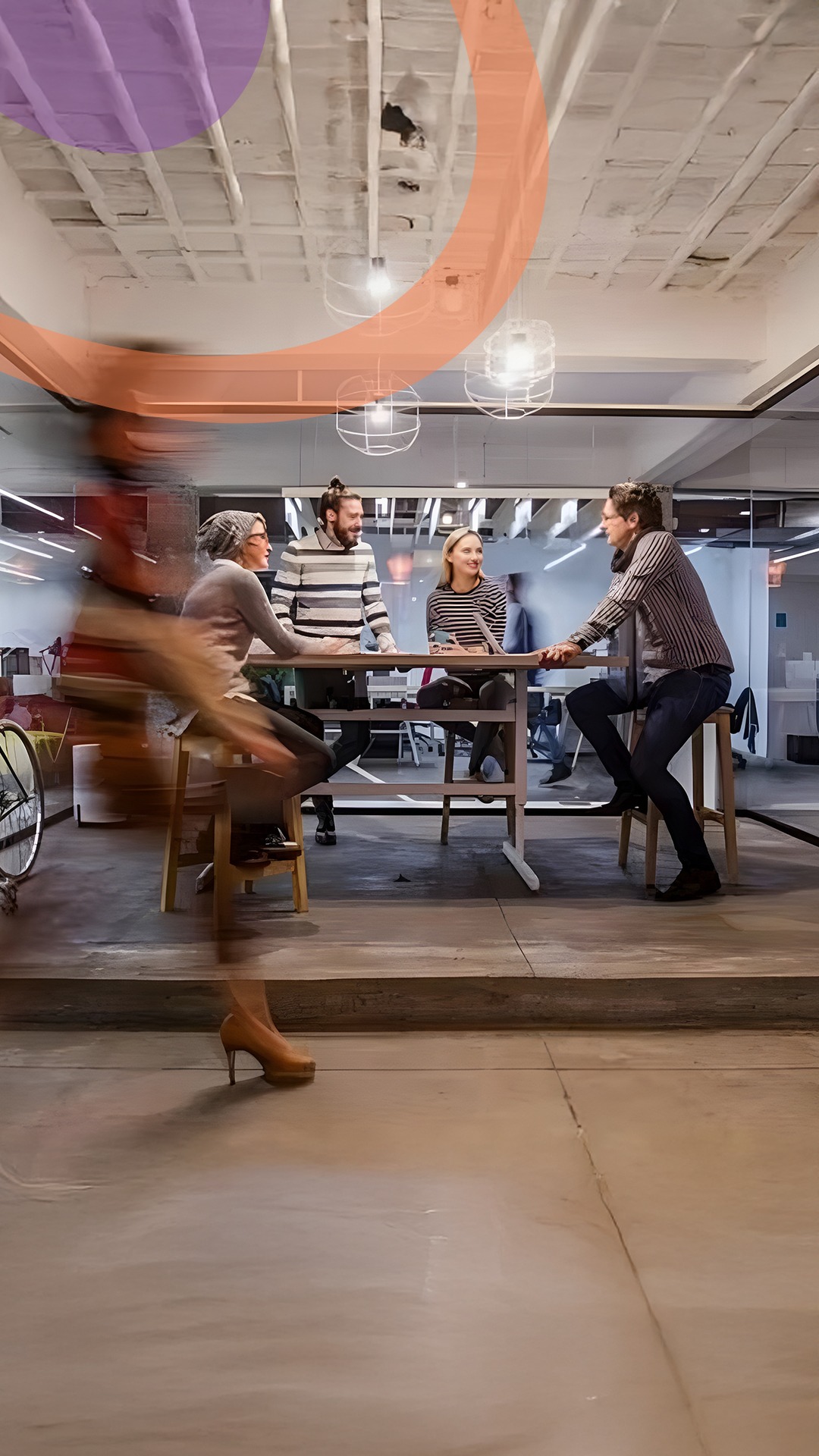 Pessoas caminhando em ambiente empresarial, pessoas sentadas numa mesa ao fundo