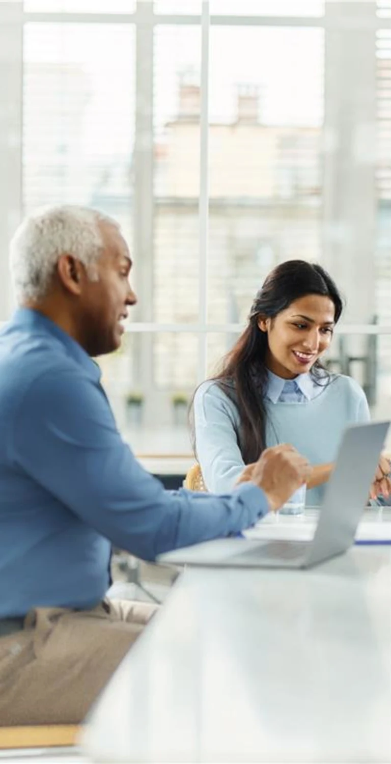 Pessoas sentadas em uma mesa de trabalho conversando