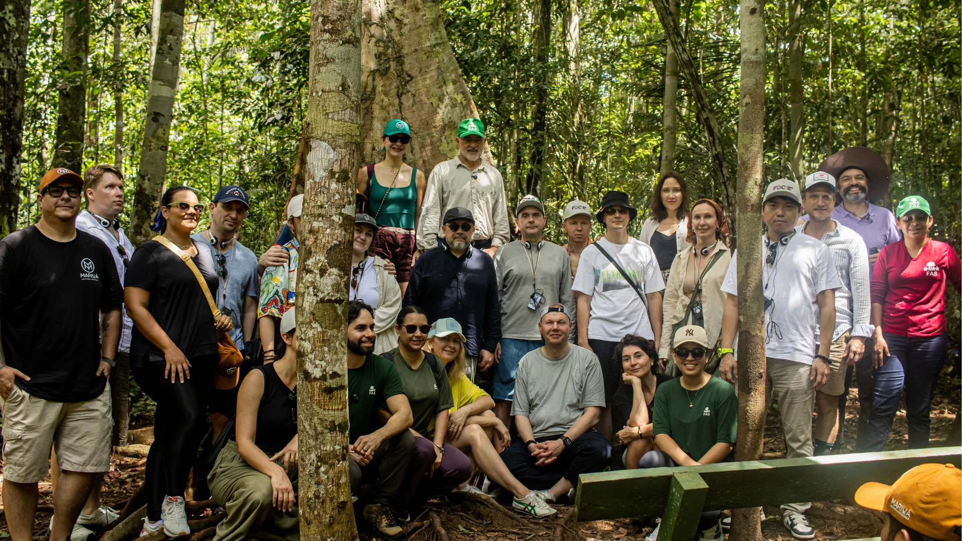 Group photo of visitors and local participants standing together in a tropical rainforest during a guided nature and cultural experience.