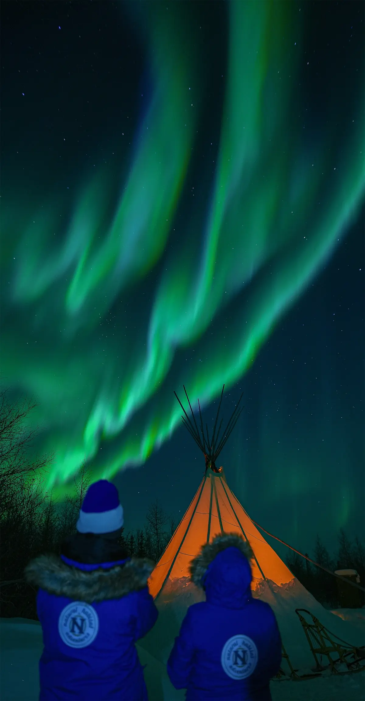 Nat Hab Guests viewing northern lights from a Métis teepee.