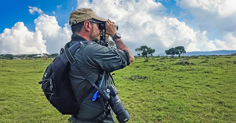 Earthwatch Scientist Dr. Antonio Uzal scopes for wildlife, Maasai Mara, Kenya.