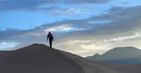 Climbing the highest dune in Great Sand Dunes National Park and Preserve at sunrise, Colorado. 