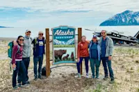 Installing the sign at Bear Camp, Alaska.