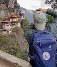 Nat Hab guest photographing Paro Taktsang Monastery (Tiger's Nest), Upper Paro Valley, Bhutan.