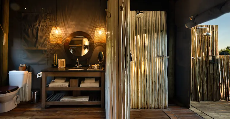 Guest tent bathroom with indoor and outdoor shower