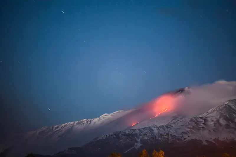 Fire meets the night of Mount Etna as lava flows illuminate the slopes of Italy.