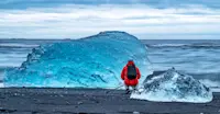 Nat Hab guest photographing iceberg at Diamond Beach, Iceland.