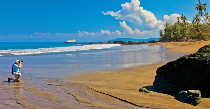 Guest photographing beach, Corcovado National Park, Costa Rica.