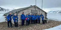 Guests in front of a cabin in Mushamna, Svalbard, Norway.