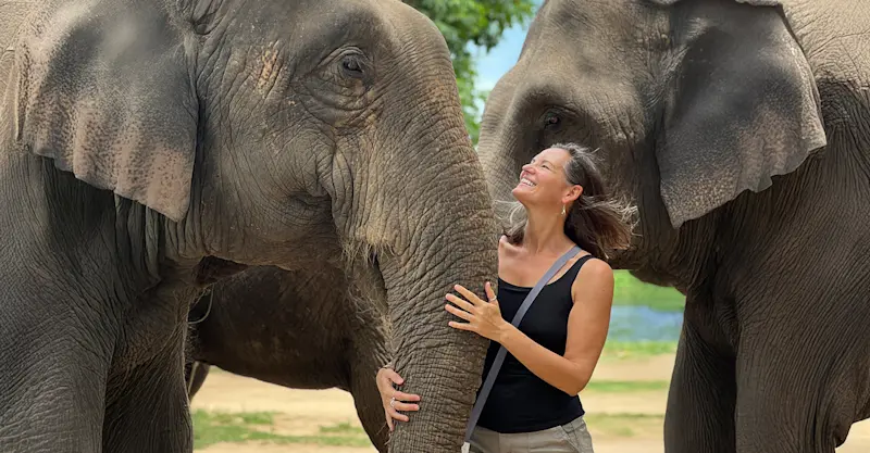 Smiling alongside gentle giants at an elephant sanctuary in Kanchanaburi, Thailand.