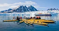 Travelers kayaking near Monaco Glacier, Svalbard.