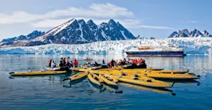 Travelers kayaking near Monaco Glacier, Svalbard.