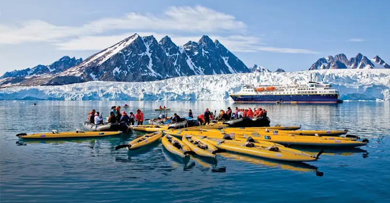 Travelers kayaking near Monaco Glacier, Svalbard.