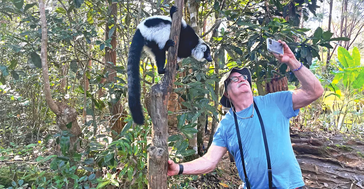 Nat Hab guest and black-and-white ruffed lemur, Ranomafana National Park, Madagascar.