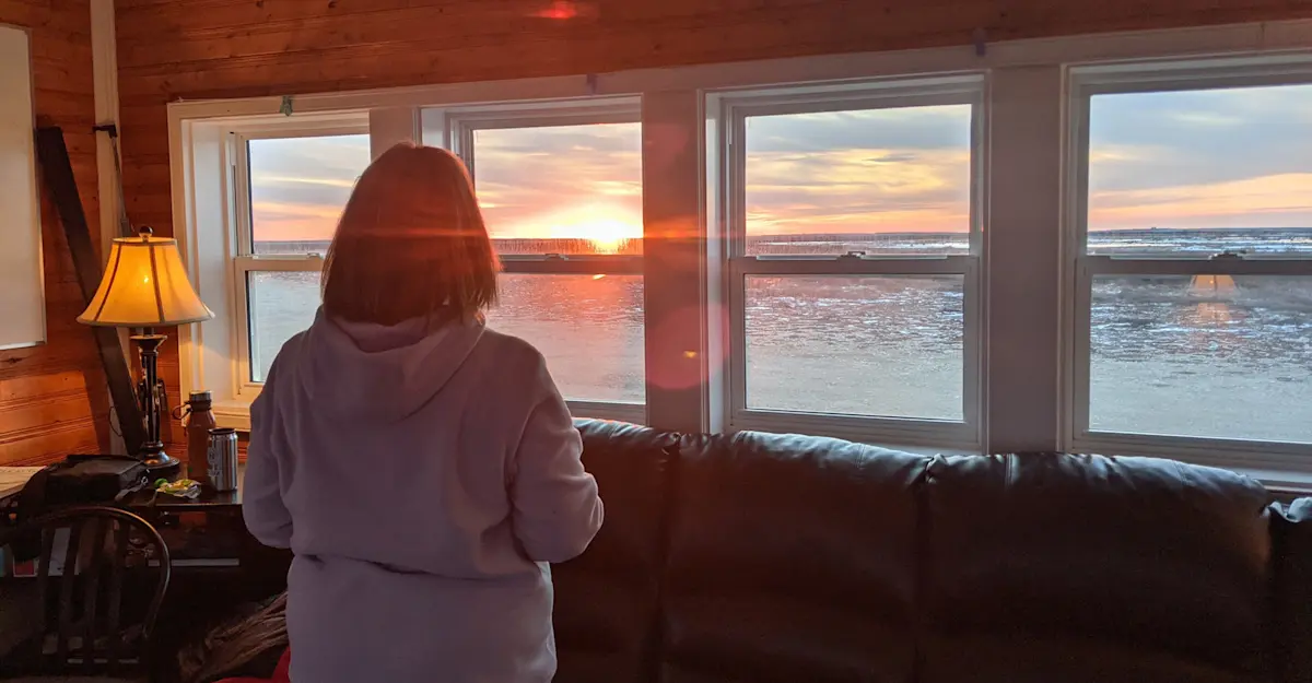 Traveler taking in the views from inside Nat Hab's Tundra Lodge