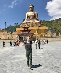 Standing in the glow of a giant golden Buddha in Bhutan.