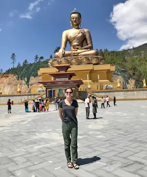 Standing in the glow of a giant golden Buddha in Bhutan.
