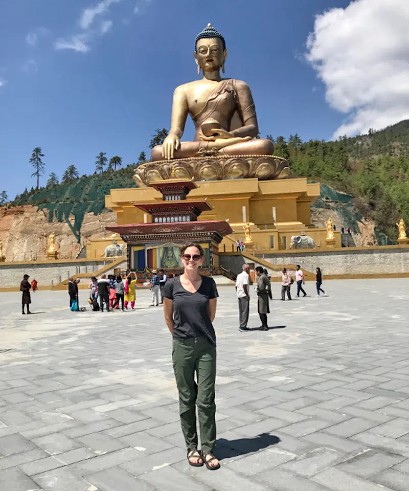 Standing in the glow of a giant golden Buddha in Bhutan.