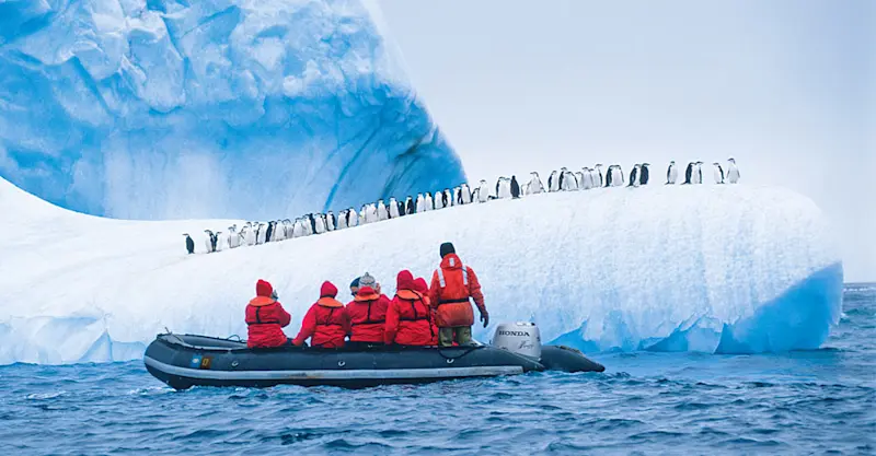 Guests in Zodiac view chinstrap penguins, Antarctica.
