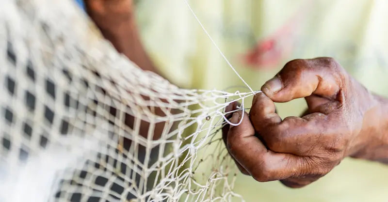 Local coastal fisherman preparing fishing nets, Belize.