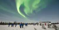 Travelers viewing northern lights outside Nat Hab's Aurora Pod®