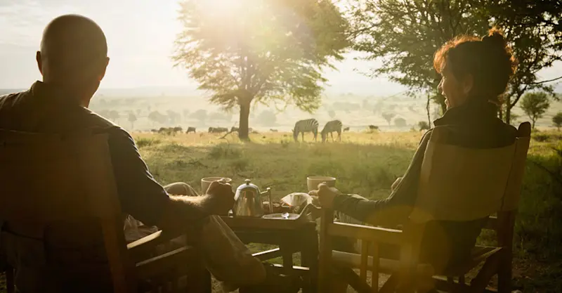 Zebras and guests at Nat Hab's Migration Camp—Serengeti National Park, Tanzania.