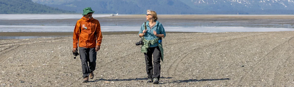 Nat Hab travelers walking along the beach of Lake Clark, Alaska