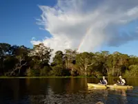 Kayaking under a rainbow in Pacaya Samiria reserve in the Amazon of Peru.