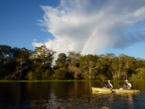 Kayaking under a rainbow in Pacaya Samiria reserve in the Amazon of Peru.