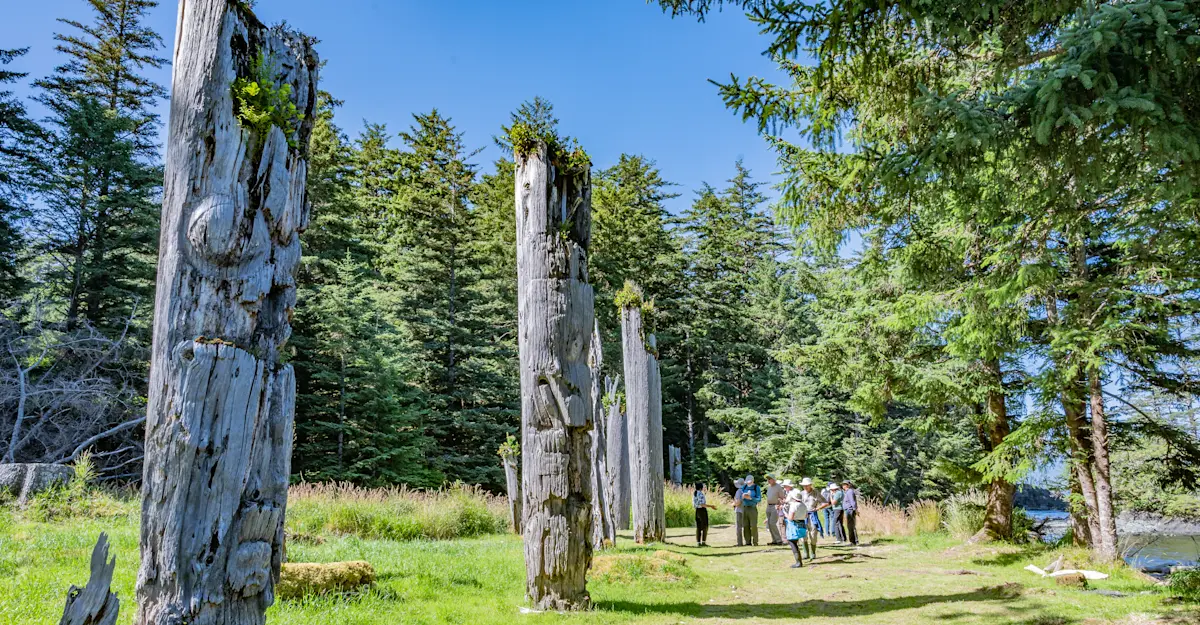 Nat Hab guests and totem poles, Gwaii Haanas National Park Reserve, British Columbia.