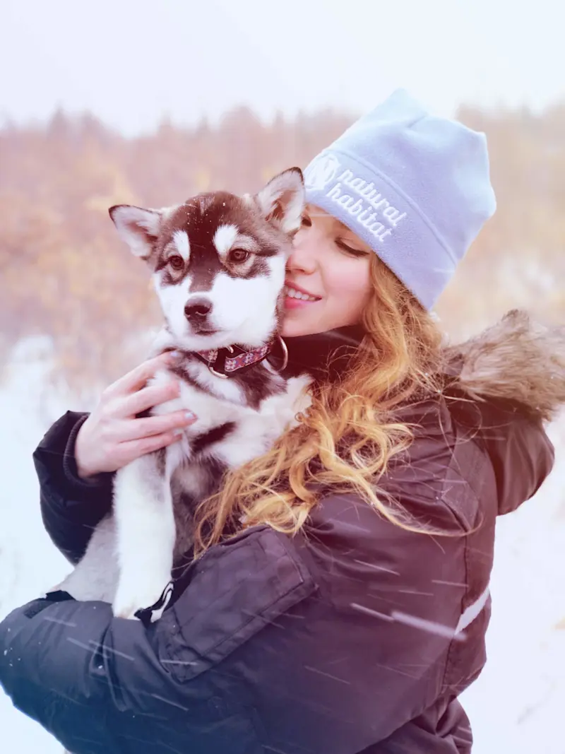 Holding a husky pup in the Polar Bear Capital of the World before dogsledding. 