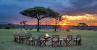 Sunset and campfire at Nat Hab's Mara East Camp, Private Mara Conservancy, Kenya.
